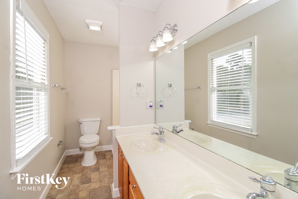 a bathroom with a large mirror and a sink and a toilet