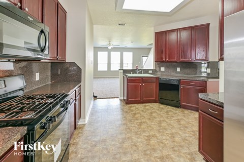 A kitchen with a stove top oven and a refrigerator.