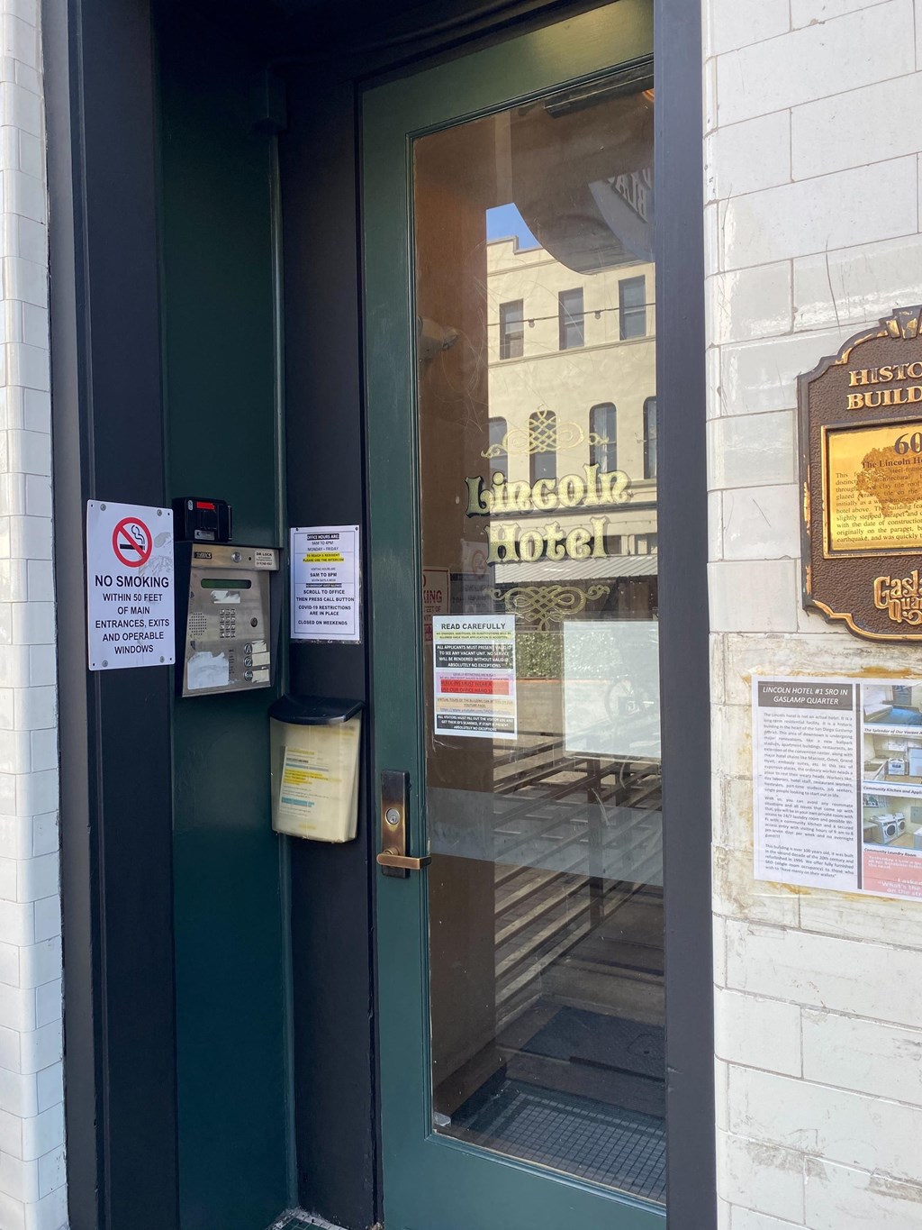 a green door with signs on the side of a building