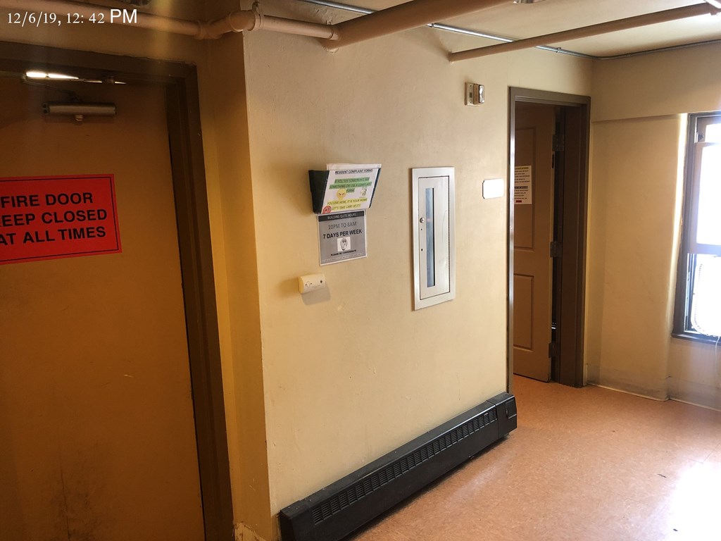 a corridor with a sign on the wall and a door that says the door is