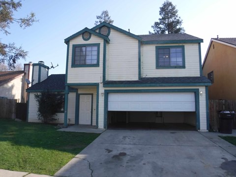 a white and green house with a garage door