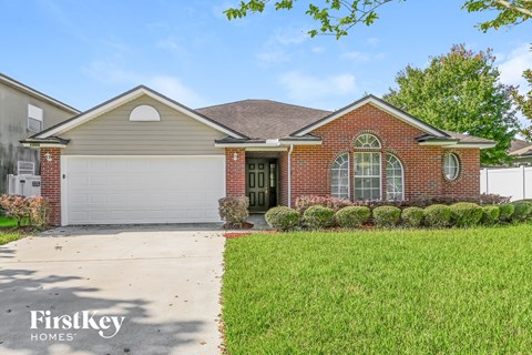 a brick house with a white garage door and a lawn