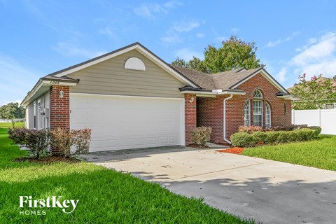a small brick house with a white garage door