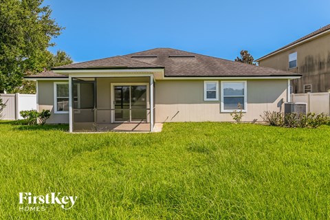 a beige house with a grassy yard in front of it