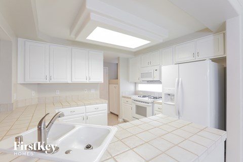 A kitchen with white cabinets and appliances.