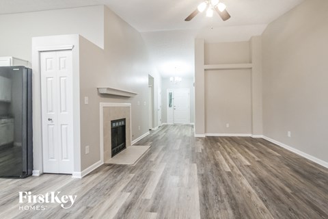 A spacious room with wooden flooring and a ceiling fan.