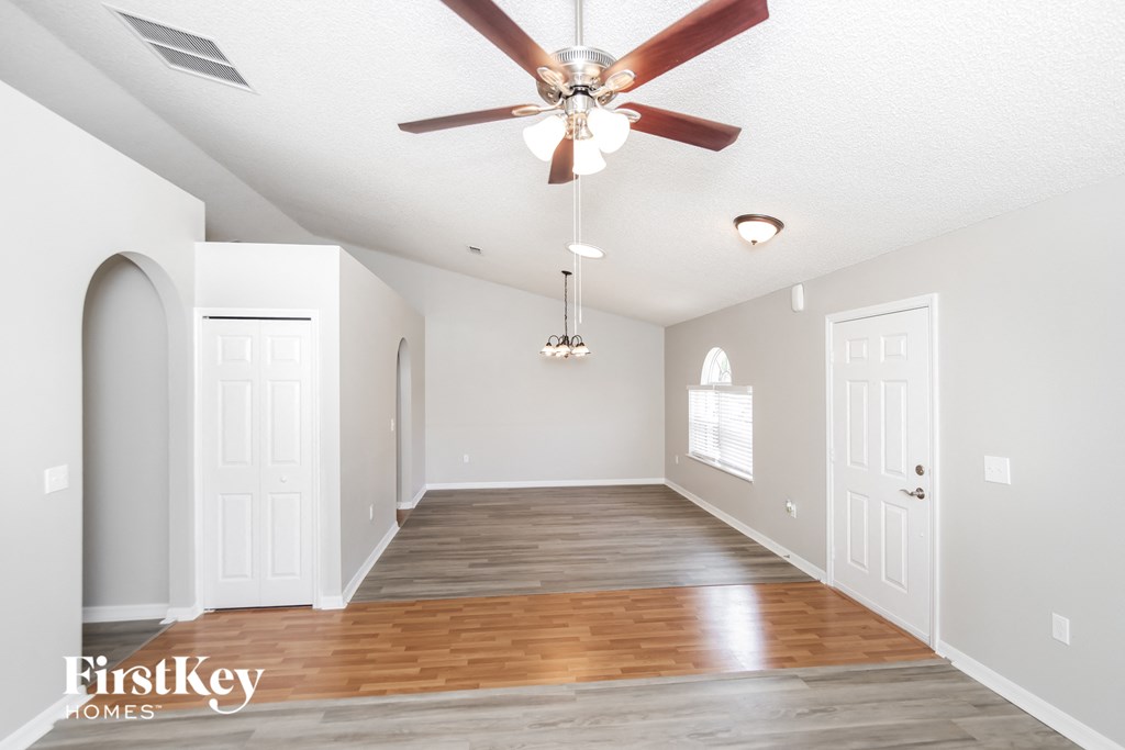 the living room and dining room with hardwood flooring and a ceiling fan