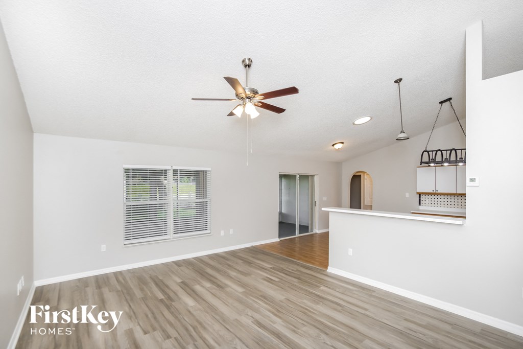 the living room and dining room with the kitchen in the background