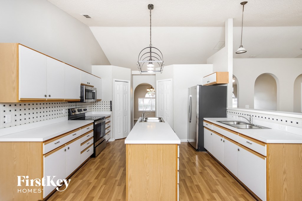 a kitchen with white cabinets and black appliances