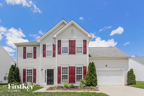 a white house with red shutters and a blue sky