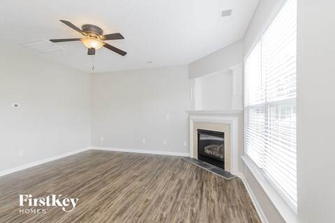 a living room with a fireplace and a ceiling fan