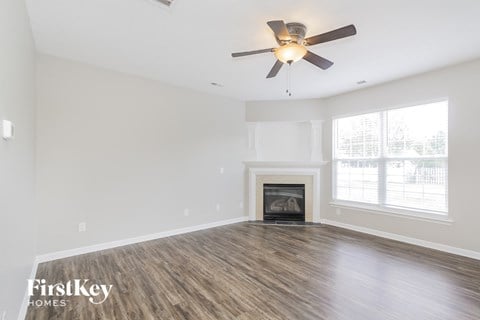 a living room with a fireplace and a ceiling fan