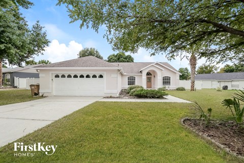 a white house with a driveway and a lawn