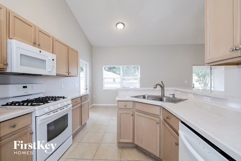 a kitchen with white appliances and wooden cabinets