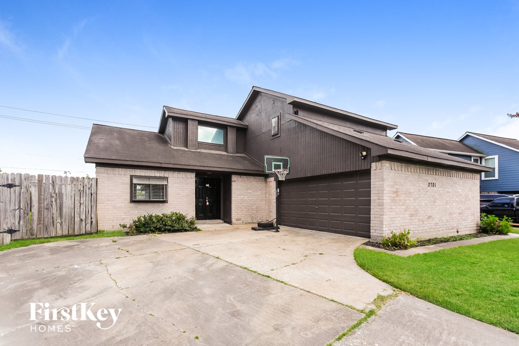 a small brick house with a driveway in front of it