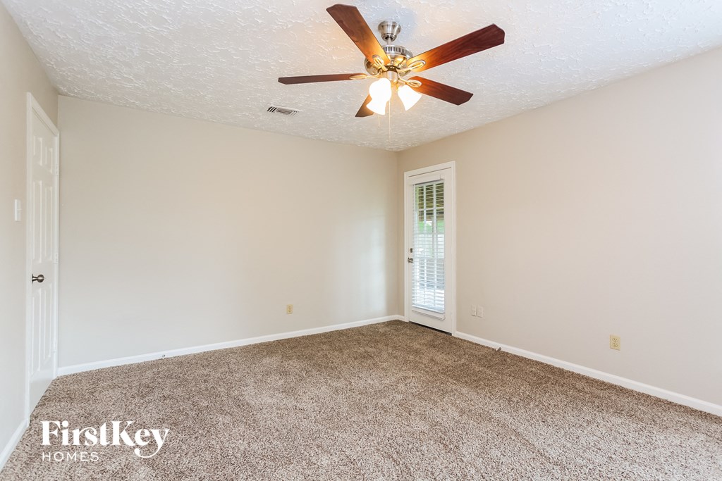 a living room with carpet and a ceiling fan