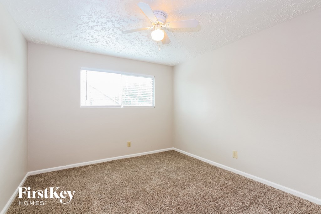 a bedroom with carpet and a ceiling fan