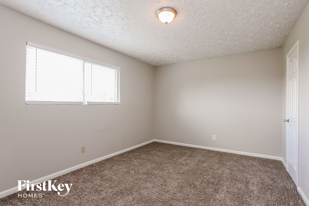 a bedroom with a carpeted floor and a window