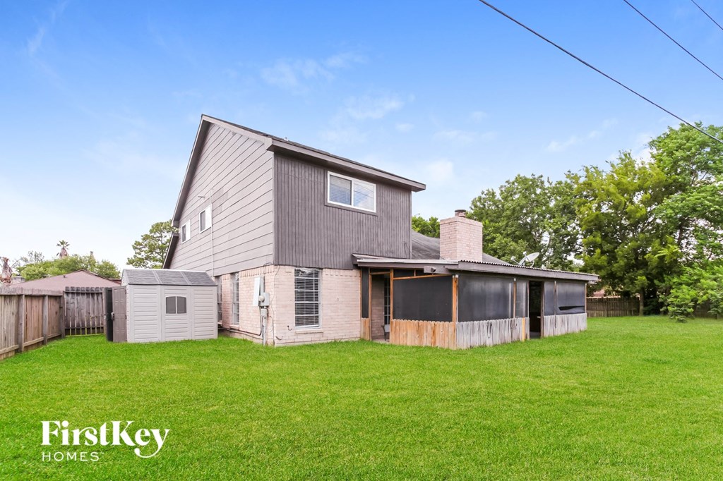 a home with a gray house and a yard and a fence