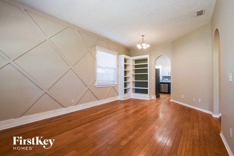 A room with wooden floors and a FirstKey Homes logo.