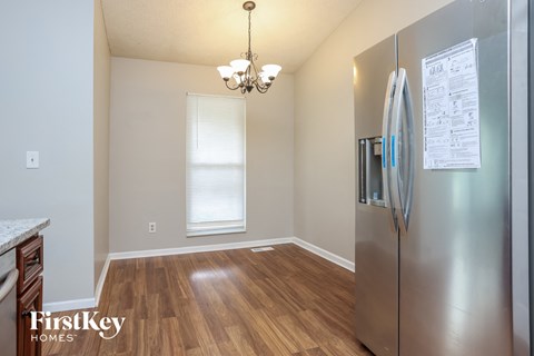 A kitchen with a refrigerator and a chandelier.