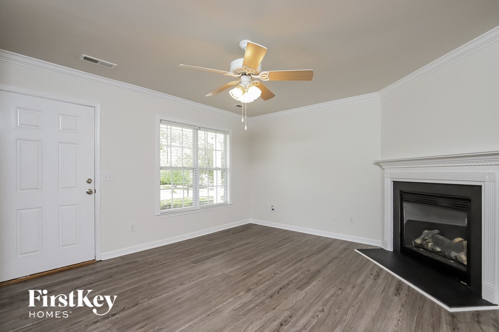 A room with a fireplace and a ceiling fan.