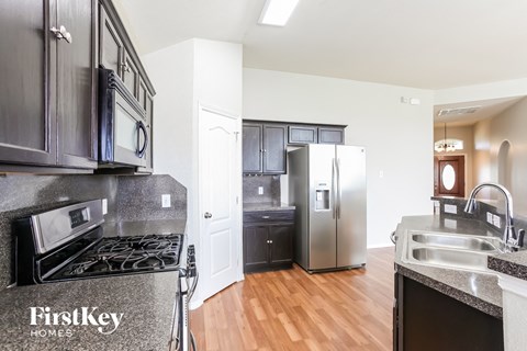 A kitchen with a stove top oven and a refrigerator.