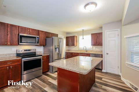 A kitchen with wooden cabinets and a granite countertop.