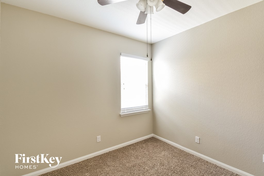 a bedroom with a ceiling fan and a window