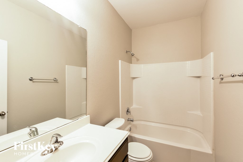 a white bathroom with a tub and a sink and a toilet