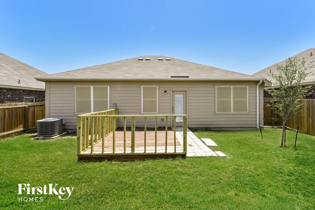 a backyard with a deck and a house