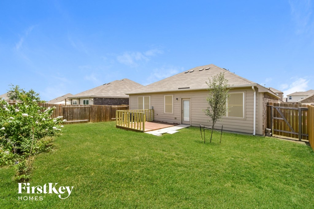 a home with a yard and a deck and a fence