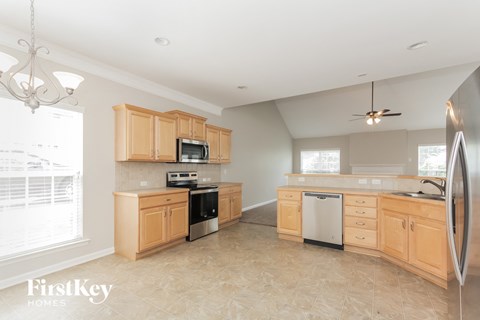 A kitchen with wooden cabinets and a refrigerator.