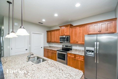 a kitchen with granite counter tops and wooden cabinets and stainless steel appliances