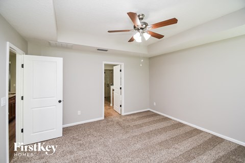 a living room with carpet and a ceiling fan