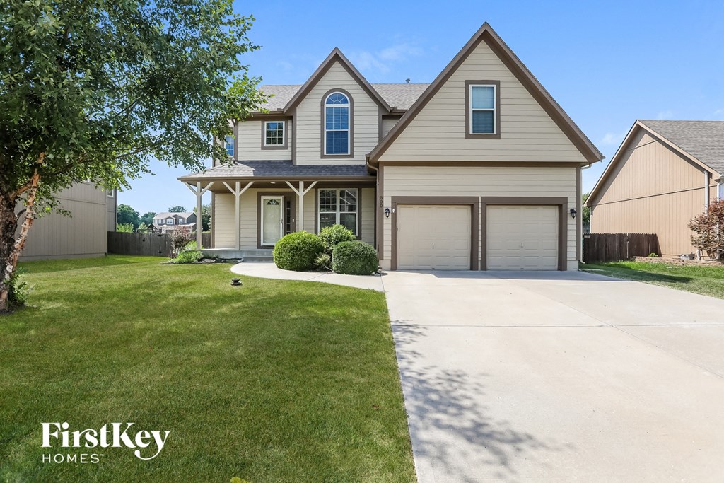 a beige house with a driveway and a garage door
