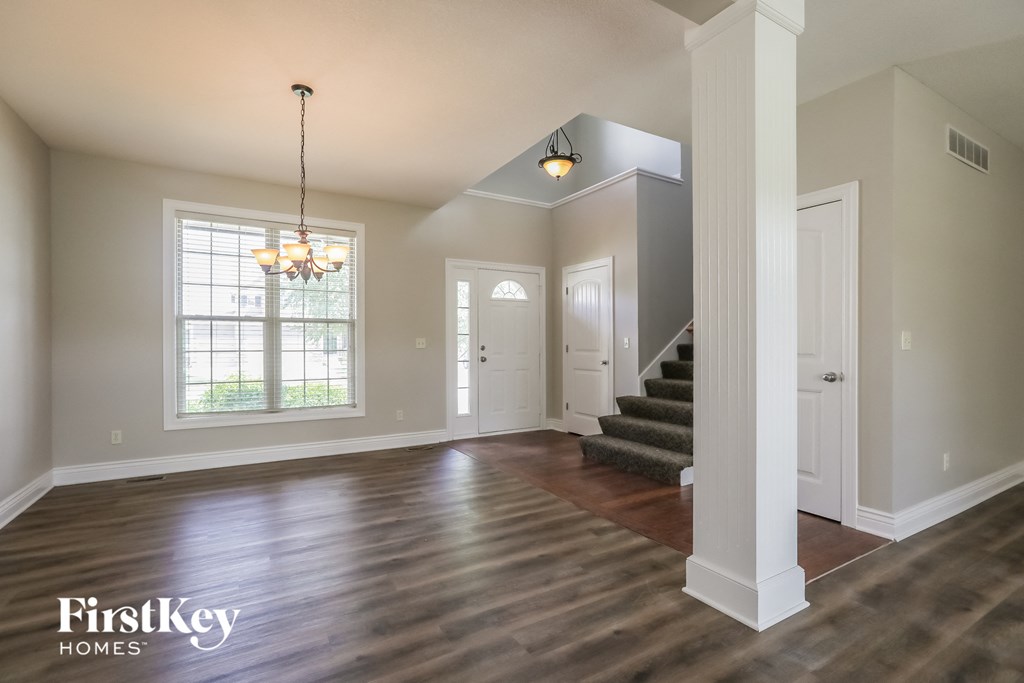 the living room and entryway of an empty house