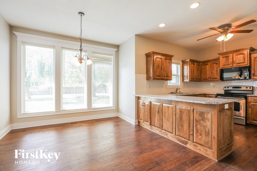an empty kitchen with wooden cabinets and a large window
