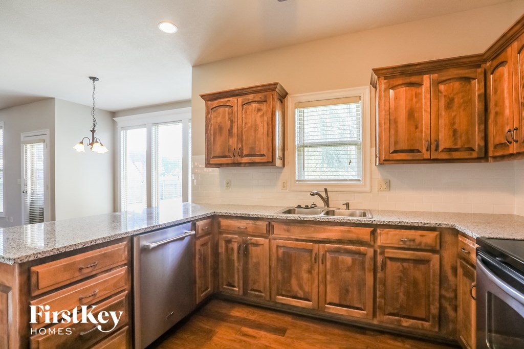 a kitchen with wooden cabinets and granite counter tops and a sink