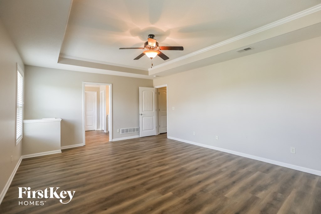 an empty living room with a ceiling fan