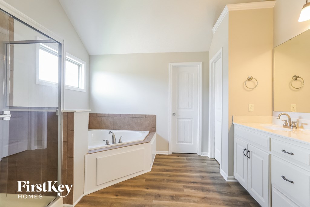 a master bathroom with a tub and a sink and a shower
