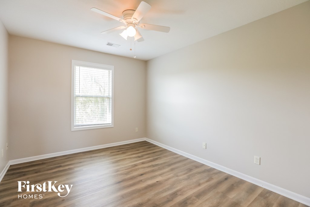 a bedroom with a ceiling fan and a window
