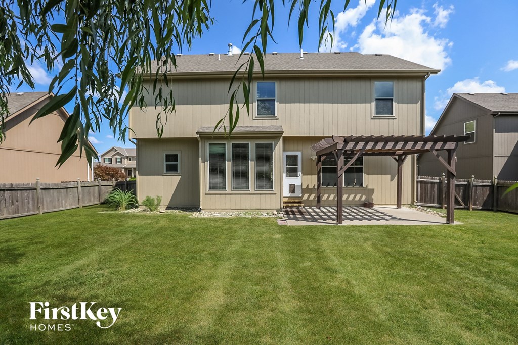 a home with a lawn and a wooden deck