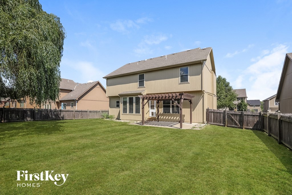 a backyard with a house and a green lawn