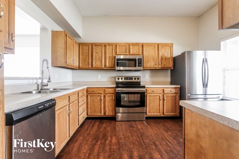 A kitchen with wooden cabinets and a stainless steel refrigerator.