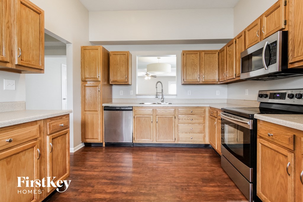 A kitchen with wooden cabinets and a stainless steel dishwasher.