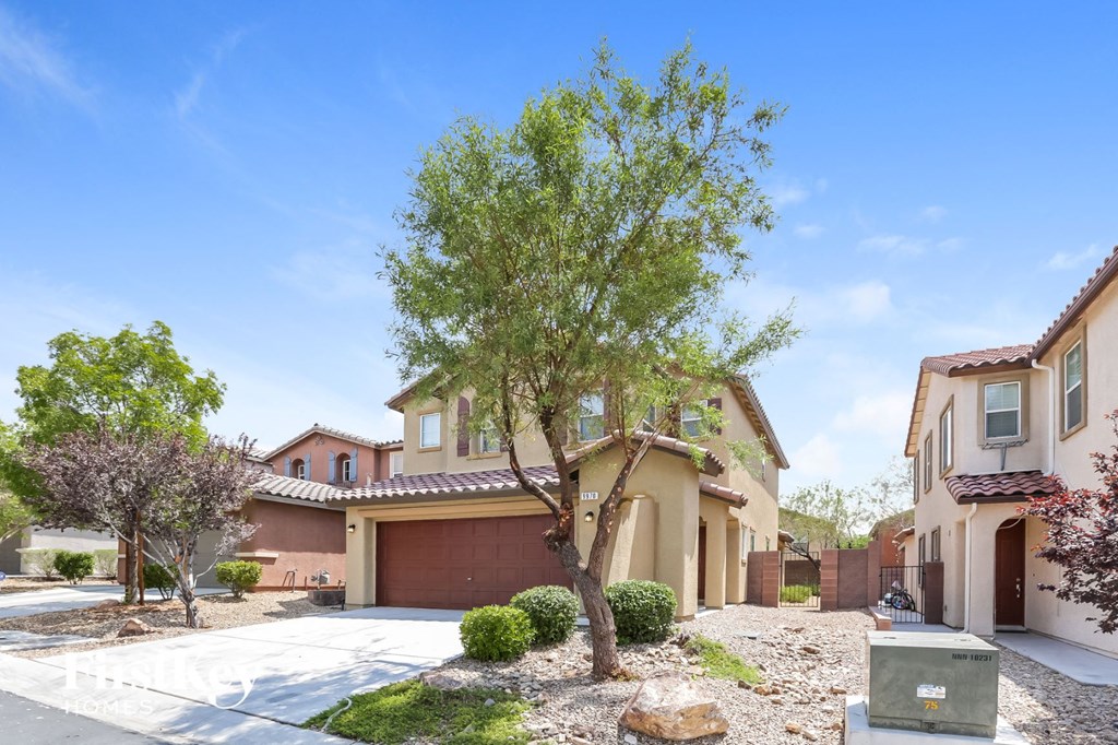 a house with a tree in front of a driveway