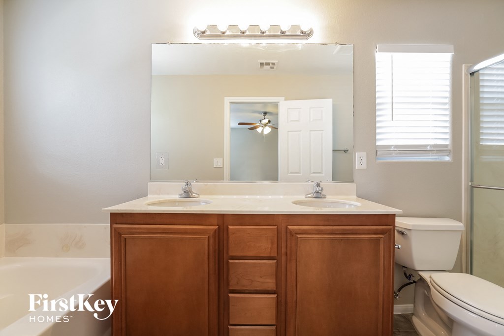 a bathroom with a toilet sink and mirror and a shower