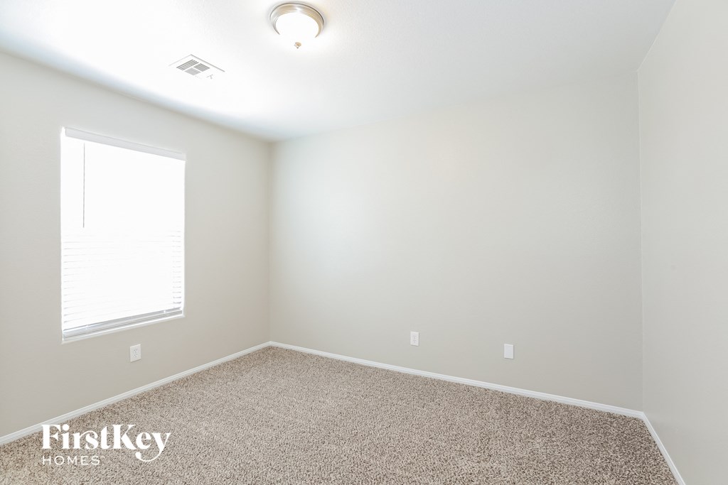 a bedroom with a carpeted floor and a window
