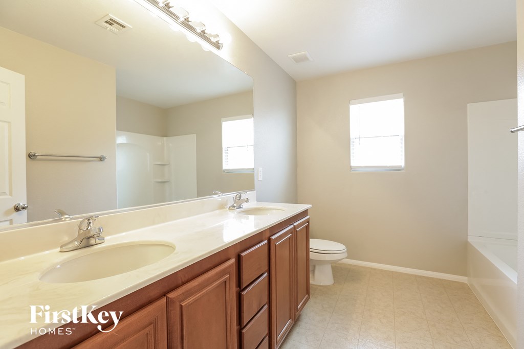 a bathroom with a large mirror and a sink and a toilet